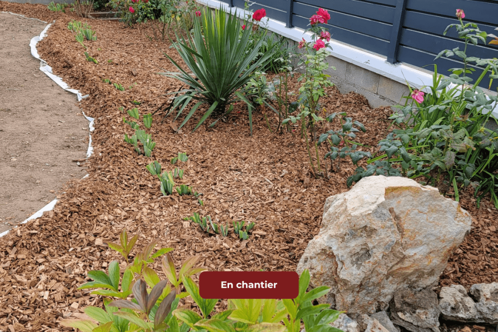 Aménagement paysager avec plantation de massifs et pose de bordures décoratives.
